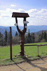 A wooden signpost on a mountain trail with a beautiful view of the mountains in the background. Mountain hiking. Concept for holidays and weekends.
