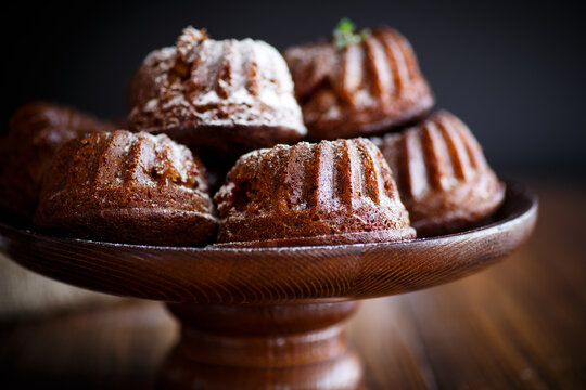 sweet honey muffins in powdered sugar on a wooden table