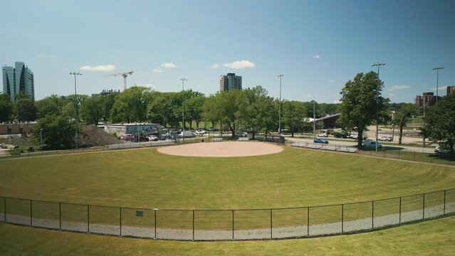 Aerial View of an Empty Baseball Field on a Sunny Day in Downtown Halifax, Canada. Inspirational Sporty Look at Youth Athletics in a Public park. View from the Outfield Near the Massive Lights.