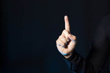 A business person showing a finger up. Hand gesture isolated on a black background. Point up.