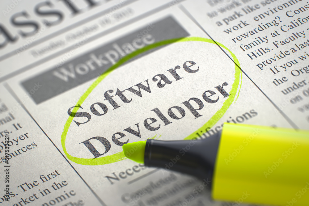 Poster software developer. newspaper with the vacancy, circled with a yellow marker. blurred image. selecti