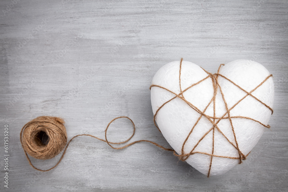 Poster heart bound by a string on grey rustic background