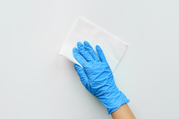 a hand in a blue glove wipes the dust with a white rag. cleaning concept