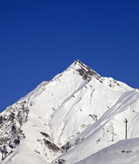 Fototapeta na wymiar Snowy mountains and blue clear sky in nice day. Caucasus Mountains, Georgia, region Gudauri.