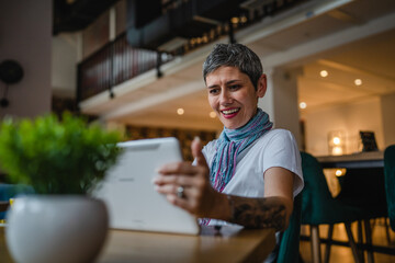 Fototapeta premium One woman mature adult senior female use digital tablet at cafe