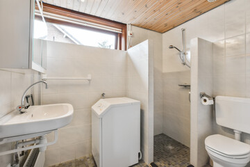 a bathroom with a toilet, sink and mirror in the same room on the left side of the photo is an open window