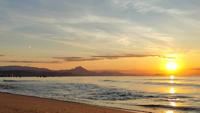 Scenery. Bright, orange sunrise over the sea and beach. Alicante San Juan beach.