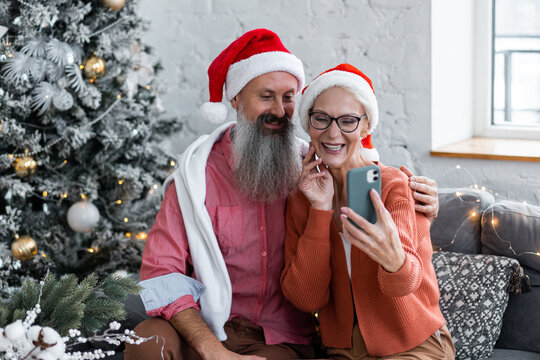 Happy couple of senior man and woman, mature people, pensioners doing video call with family, grandchildren on Christmas or new year. Holiday season, connection with beloved. Making selfie
