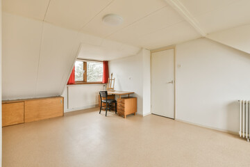 Fototapeta premium an empty room with a desk, chair and rad in the corner on the left is a window that looks out onto the