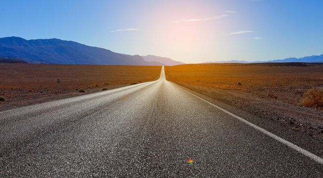 empty beautiful road in death valley national parl, california, sun flare, travel concept