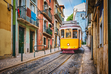 Plakat Famous vintage yellow tram 28 in the narrow streets of Alfama district in Lisbon, Portugal - symbol of Lisbon, famous popular travel destination and tourist attraction