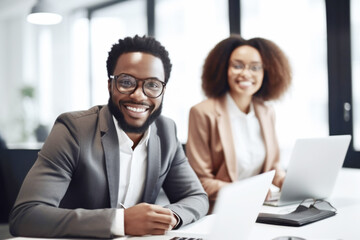 Happy smiling black business man in a meeting with his  female colleague in the office
