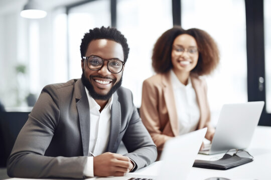 Happy smiling black business man in a meeting with his  female colleague in the office