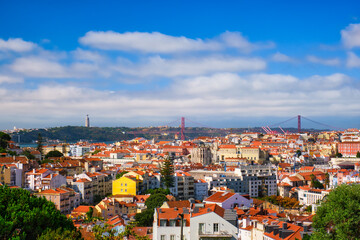 Lisbon famous view from Miradouro dos Barros tourist viewpoint over Alfama old city district, 25th of April Bridge and Christ the King statue. Lisbon, Portugal.