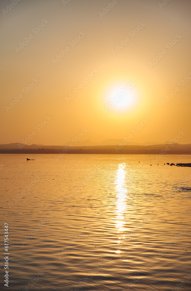 Wall mural view of the salt lake with a beautiful pink water. sunset orange sun, the neighborhood.las salinas, 