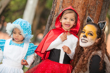 Real family having fun while using costumes of the Little red riding hood tale in Halloween.