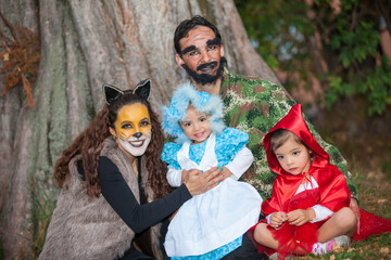 Real family having fun while using costumes of the Little red riding hood tale in Halloween.