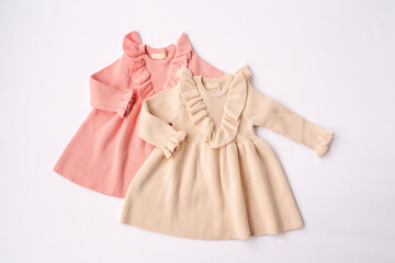 Beige and pink dresses for girls. Children's fashion, children's wardrobe. White background, top view. High quality photo