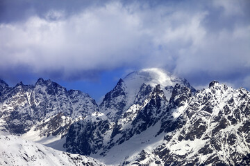 Fototapeta na wymiar Snow mountaims in clouds at sunny winter day. Caucasus Mountains. Svaneti region of Georgia.