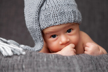 Beautiful newborn baby wearing a cute grey hat