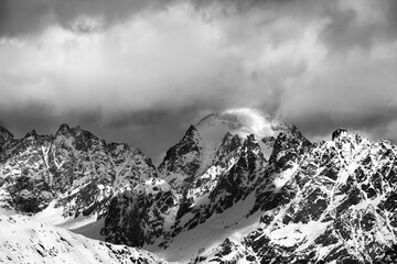 Black and white snow mountains in clouds at sunny winter day. Caucasus Mountains. Svaneti region of Georgia.