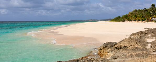 panorama of rocky rugged shore with white sand beach and turquoise lagoon at anguilla island
