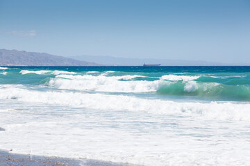 Beach of fine sand and waves, choppy seas