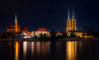 Illuminated Ostrow Tumski in Wroclaw in Poland with reflection in Odra river