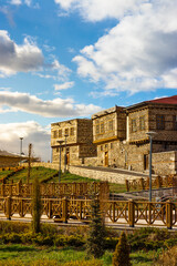 Fototapeta na wymiar Stone houses of historical Erzurum with fence and cloudy sky in the background