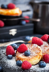 Cottage cheese pancakes decorated with fresh raspberries and blueberries
