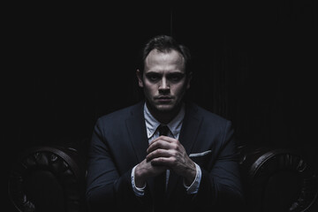 Portrait of a businessman in a suit on black background