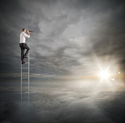 Fototapeta na wymiar Businessman on a ladder high into the sky watching with binoculars