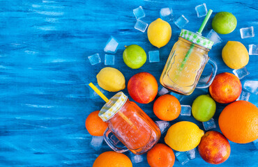 Citrus vitamin juice in mason jars with fresh oranges, mandarins, lemons and limes around, healthy...