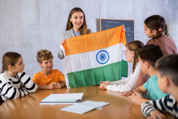 Female mentor teacher working with students in school class, talking about national flag of India at history lesson
