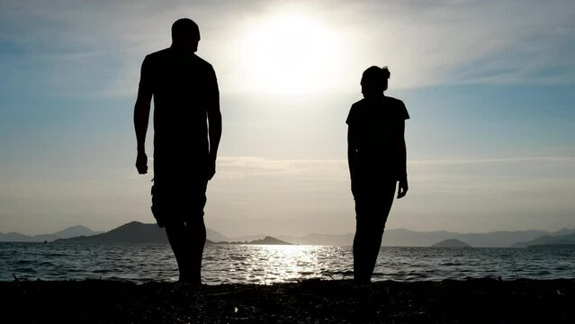 Silhouette of an offended couple in love. Offended man and woman stand with their backs to each other.