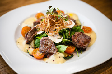 Brutus salad with beef tenderloin served on a plate