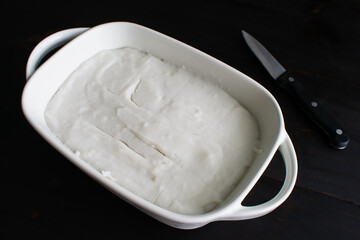 Set and Sliced Hawaiian Coconut Pudding (Haupia) in a Small Dish: Chilled coconut pudding sliced into small squares with a paring knife