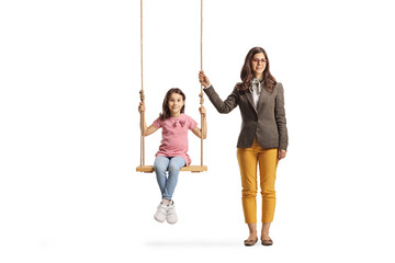 Full length portrait of a young female standing next to a girl on a wooden swing