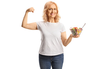 Mature woman holding a salad and showing strong muscle