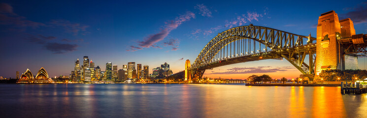 Naklejka na ściany i meble Panoramic image of Sydney, Australia with Harbour Bridge during twilight blue hour.