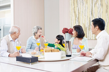 three-generation family having meal at home