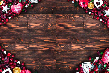 Valentine's Day Background with love themed elements like cotton and paper hearts, flowers, berries, oranges and other decorations. Wooden old parquet on the back.