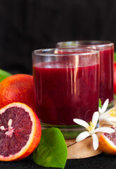 Fresh squeezed blood orange juice decorated with orange blossom. Low key photo.