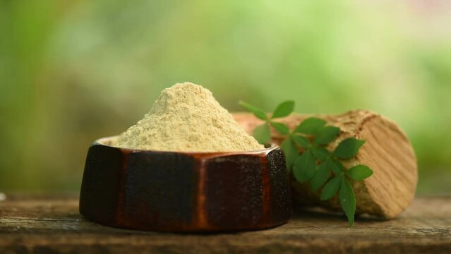 Thanaka or naringi crenulata woods ,powder and green leaves on nature background.