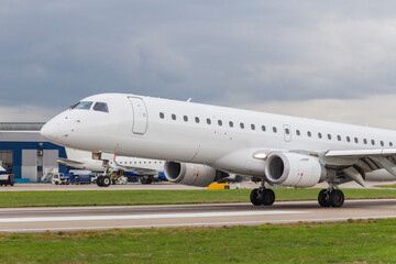 Commercial jet airliner airplane landing on the runway of a busy modern airport