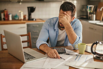 Young man going over his home finances in the kitchen