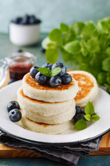 Cottage cheese pancakes with blueberries and mint, close-up.