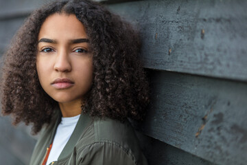 Beautiful mixed race African American girl teenager female young woman outside looking sad...
