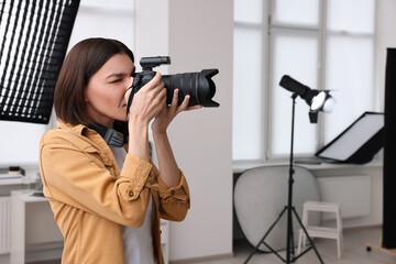 Professional photographer taking picture in modern photo studio