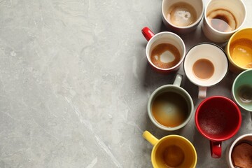 Many dirty cups after different coffee drinks on light grey marble table, flat lay. Space for text